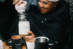 Man preparing coffee with portable coffee maker outdoors