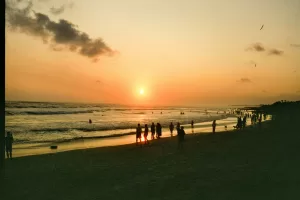 People enjoying a sunset on a sandy beach.